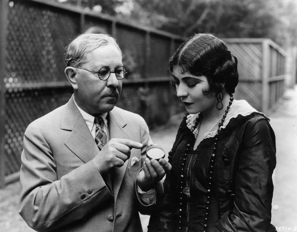 Factor advises actress Renee Adoree on a new kind of rouge. 1925.