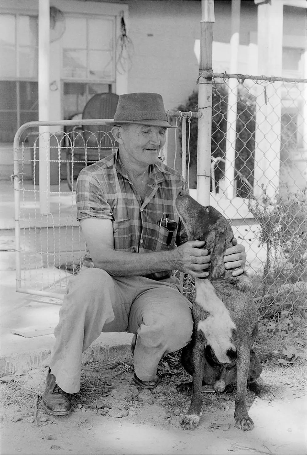 Baxterville Postmaster C.E. Bond comforts his dog Old Blu after the blast.