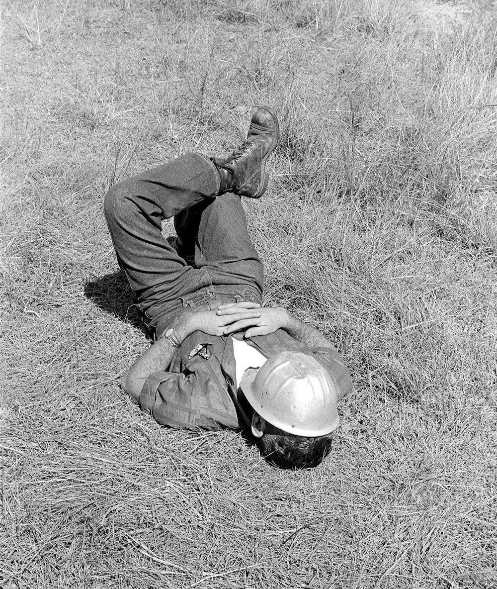 An Atomic Energy Commission worker naps while waiting for a detonation that was postponed.