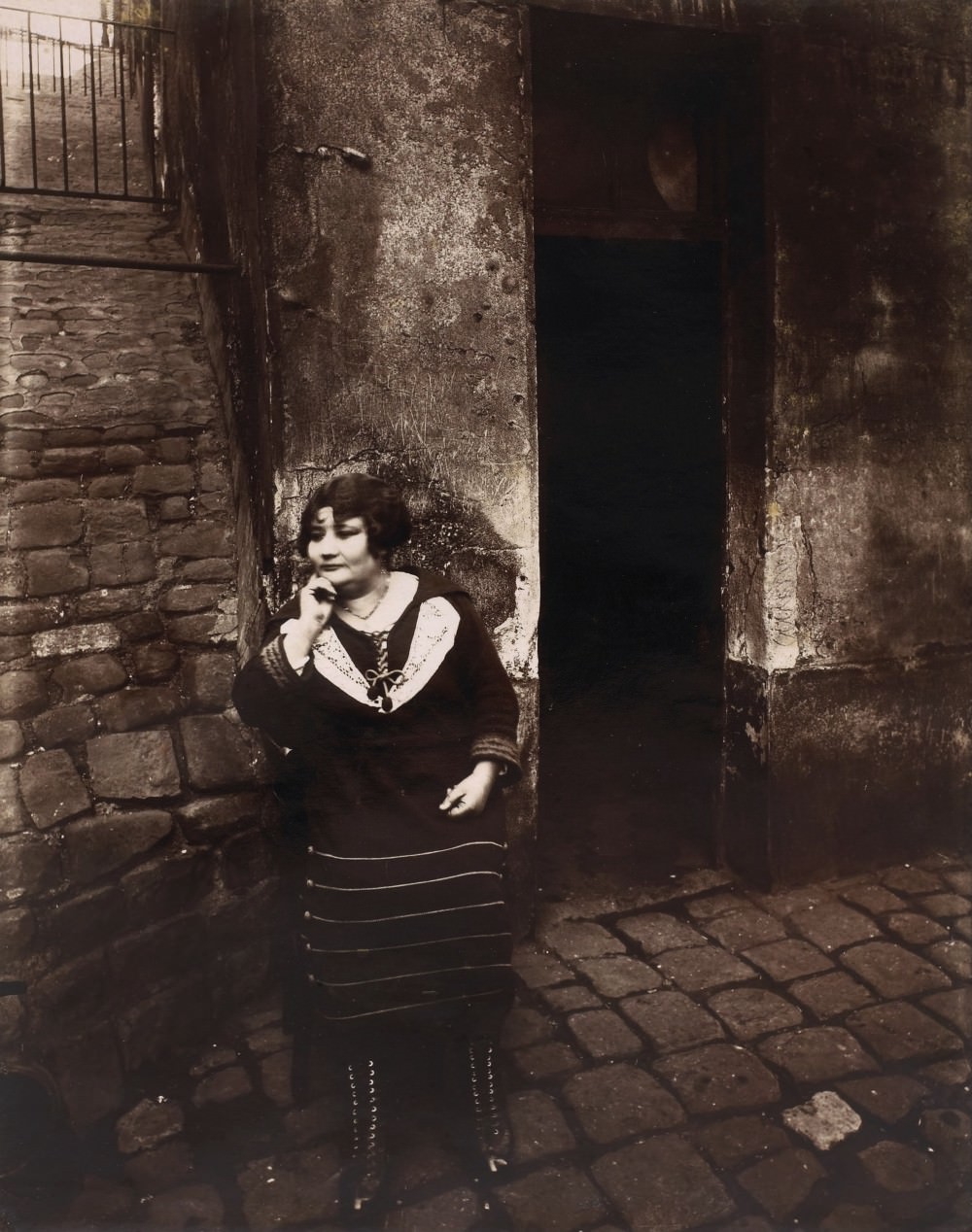La Villette, rue Asselin, a sex worker on her shift in front of her door, 1921.