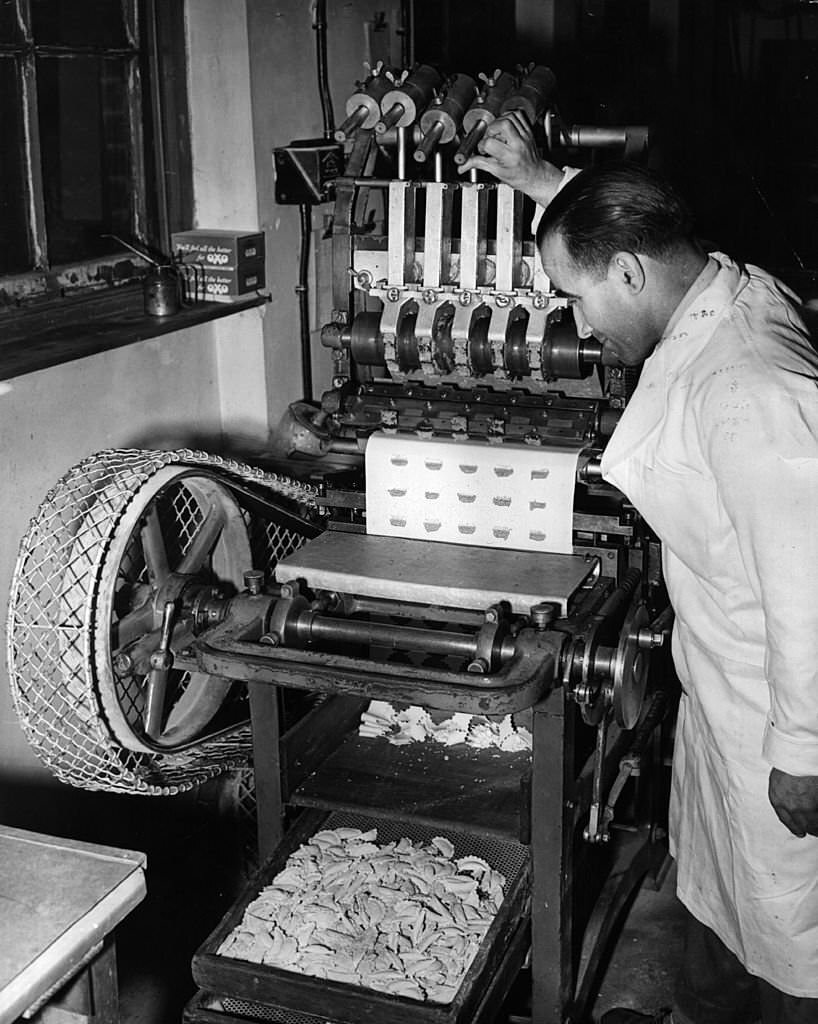 Mr Michael Pino operates a ravioli-making machine at Messrs L Ugo Ltd, London, 1955. The factory specialises in all types of pasta and rivals the imported pastas from Italy.