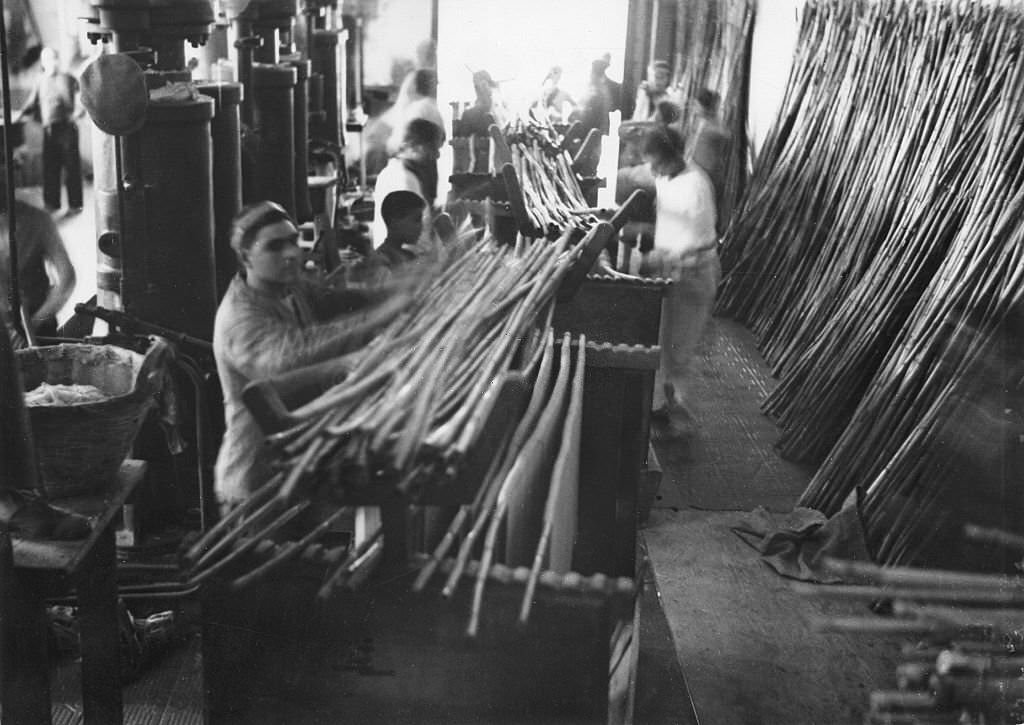 Spaghetti production Workers hanging spaghetti over bamboo sticks to dry them, 1932