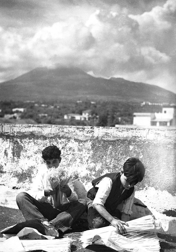 Spaghetti production Two boys packing spaghetti; in the background Mount Vesuvius, 1932