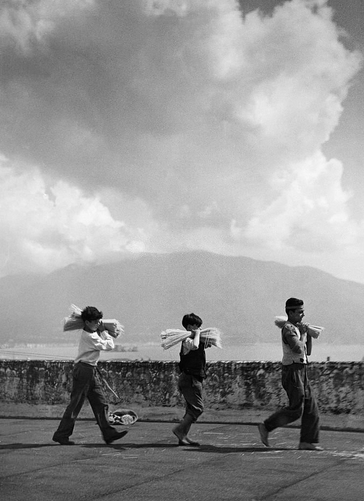 Neapolitan boys carrying a bundle of spaghetti on their shoulders; in the background Mount Vesuvius, 1932