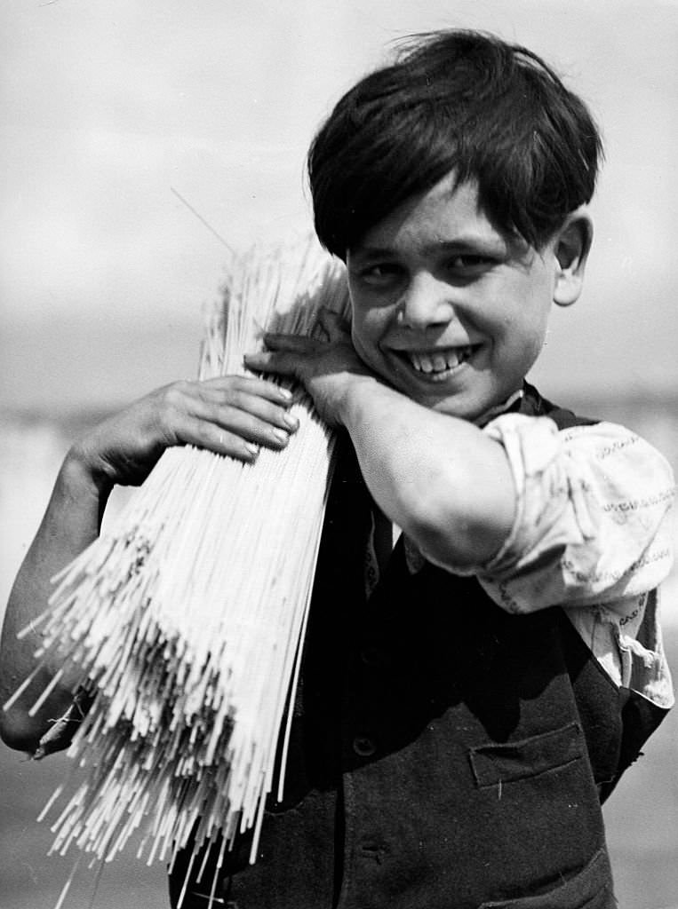 Neapolitan boy carrying a bundle of spaghetti on his shoulder, 1932