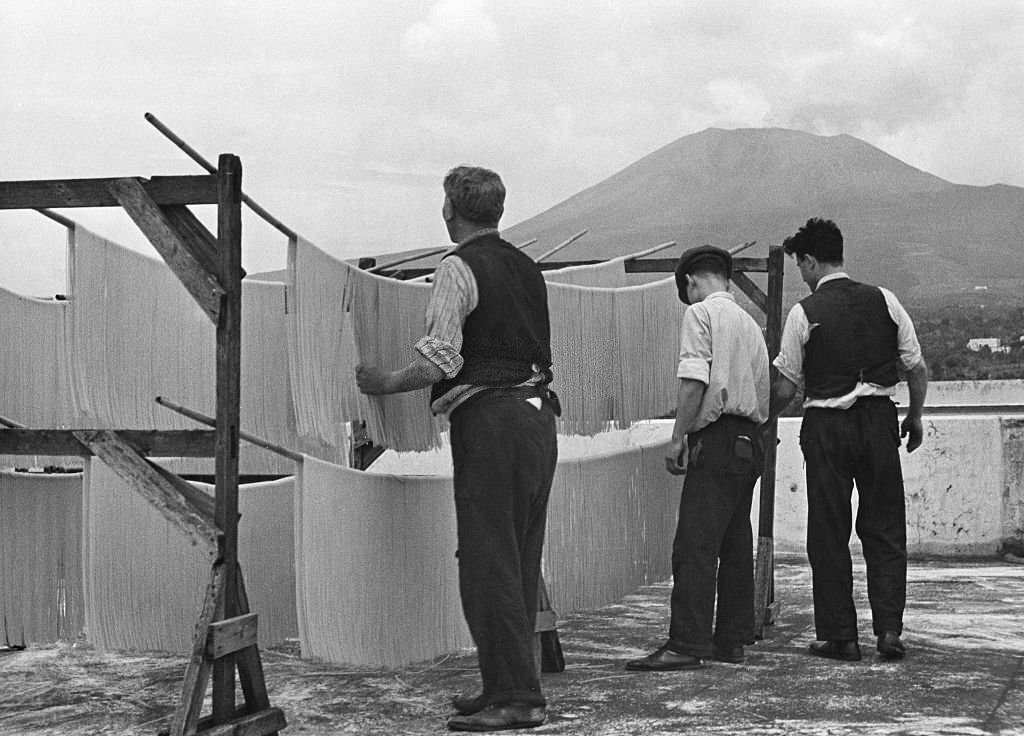 Spaghetti production Hanging up spaghetti to dry them; in the background Mount Vesuvius, 1932