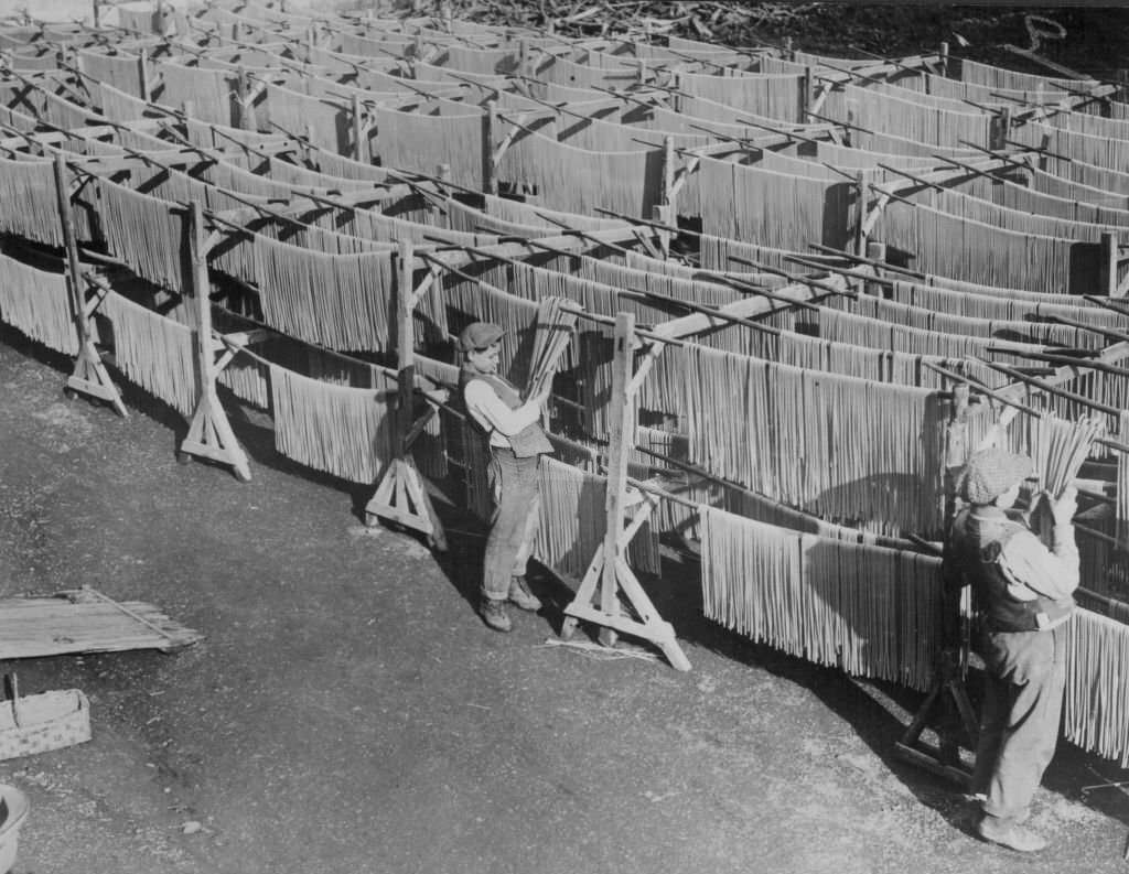 Italian boys hanging hand-made pasta in the traditional way, Italy, 1920s