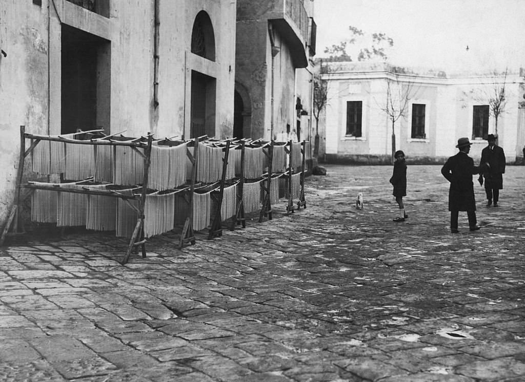 Strands of macaroni being hung out to dry, Italy, 1925.