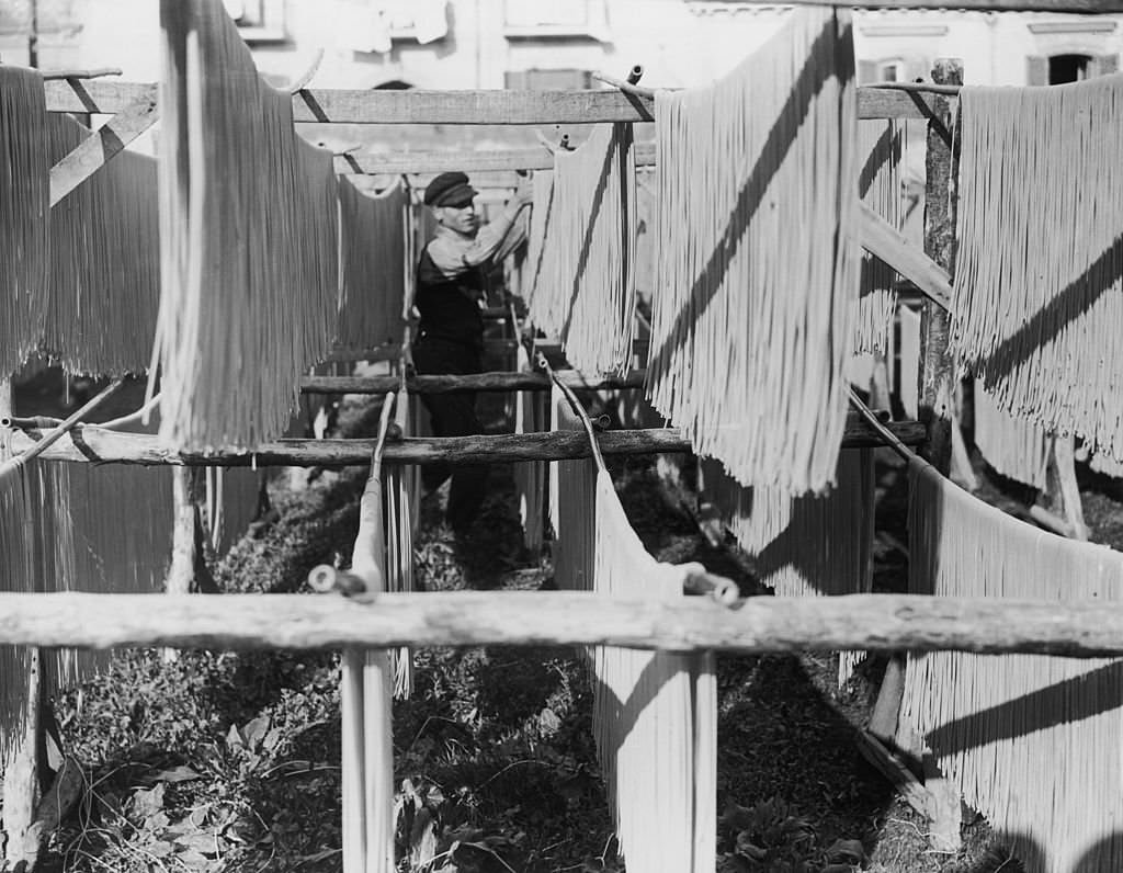 Strands of macaroni being hung out to dry, Naples, Italy, 1925.