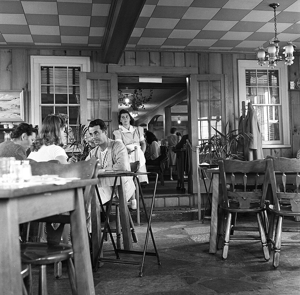 A waitress at a restaurant leans upon the doorway as she spends a quiet moment on Cape Cod, Provincetown, Massachussetts, 1947.