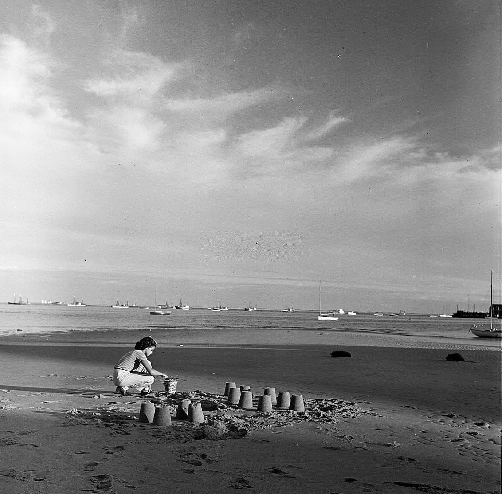 A young girl builds sand castles on the beach, Provincetown, Massachusetts, 1948.