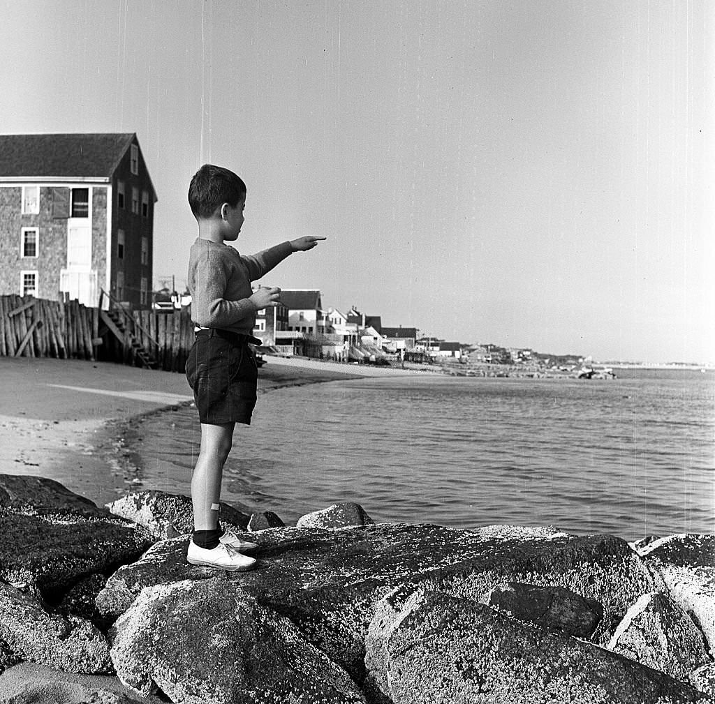 A young boy standing on the beach points towards the sea, Provincetown, Massachusetts, 1948.