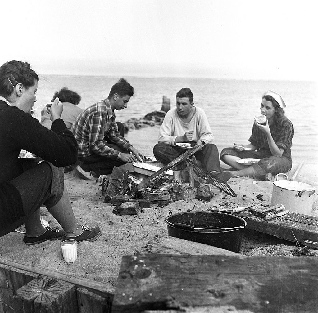 Five friends gather around for a beachside cookout, Provincetown, Massachusetts, 1948.
