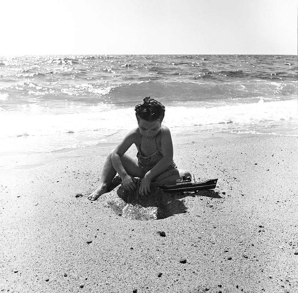 A young girl plays in the sand at the beach, Provincetown, Massachusetts, 1948.