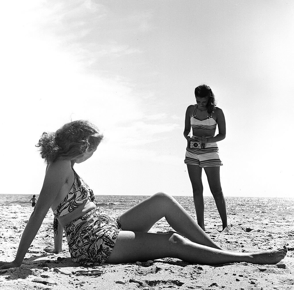 A woman takes a photograph of her friend as they visit the beach, Provincetown, Massachusetts, 1948.