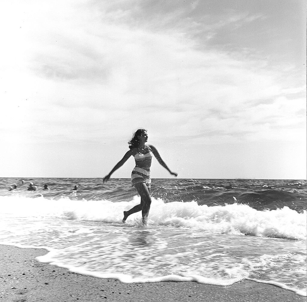 A woman runs along the beach amid the surf, Provincetown, Massachusetts, 1948.