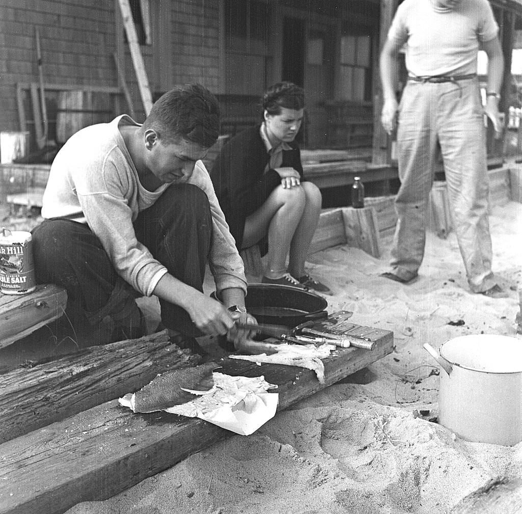 A man cleans fish for a beachside cookout, Provincetown, Massachusetts, 1948.