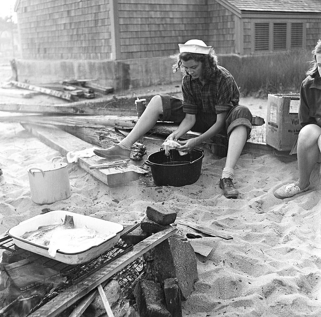 A woman cleans fish for a beachside cookout, Provincetown, Massachusetts, 1948.