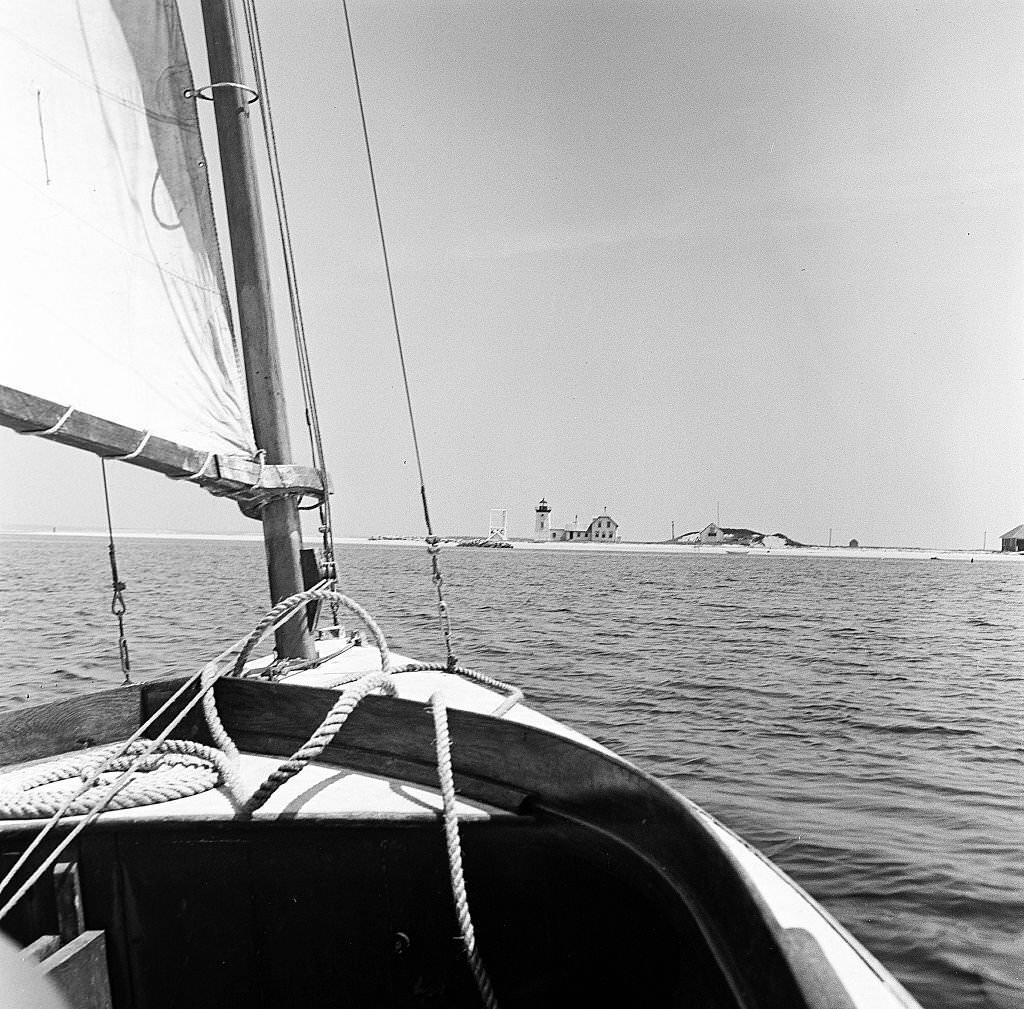 A sailboat approaches a lighthouse on Cape Cod, Provincetown, Massachussetts, 1947.