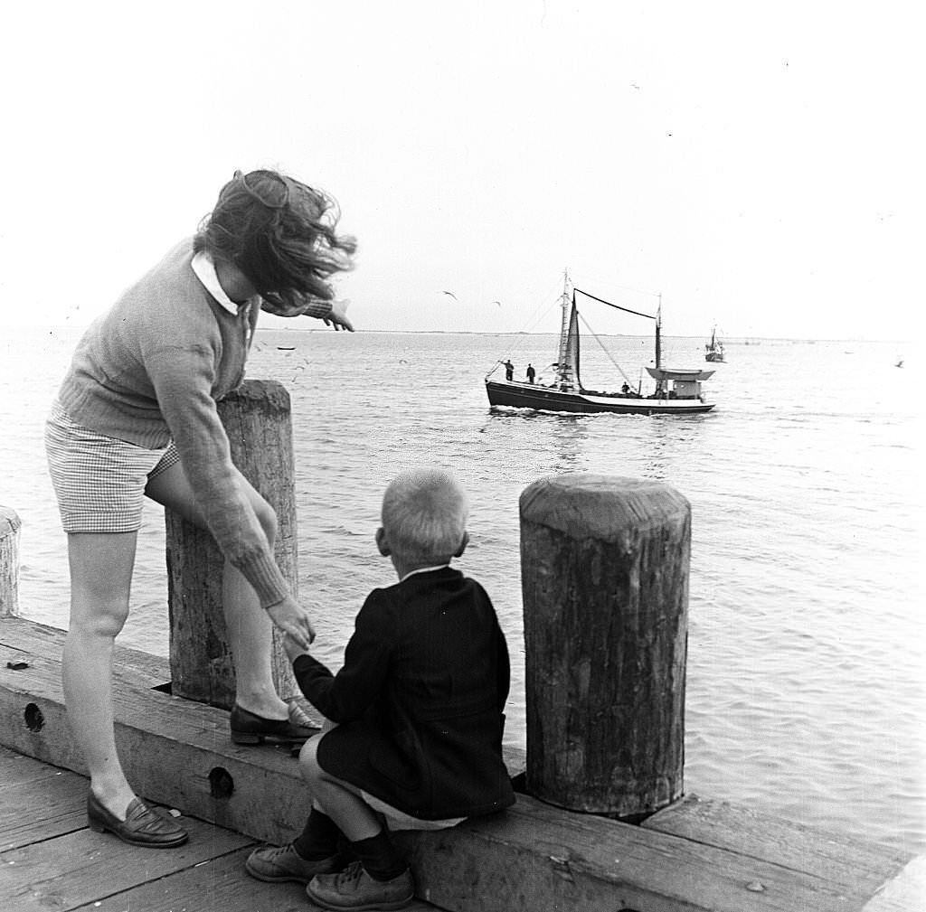 A woman points out a fishing boat to her son, at the piers, Provincetown, Massachusetts, 1948.