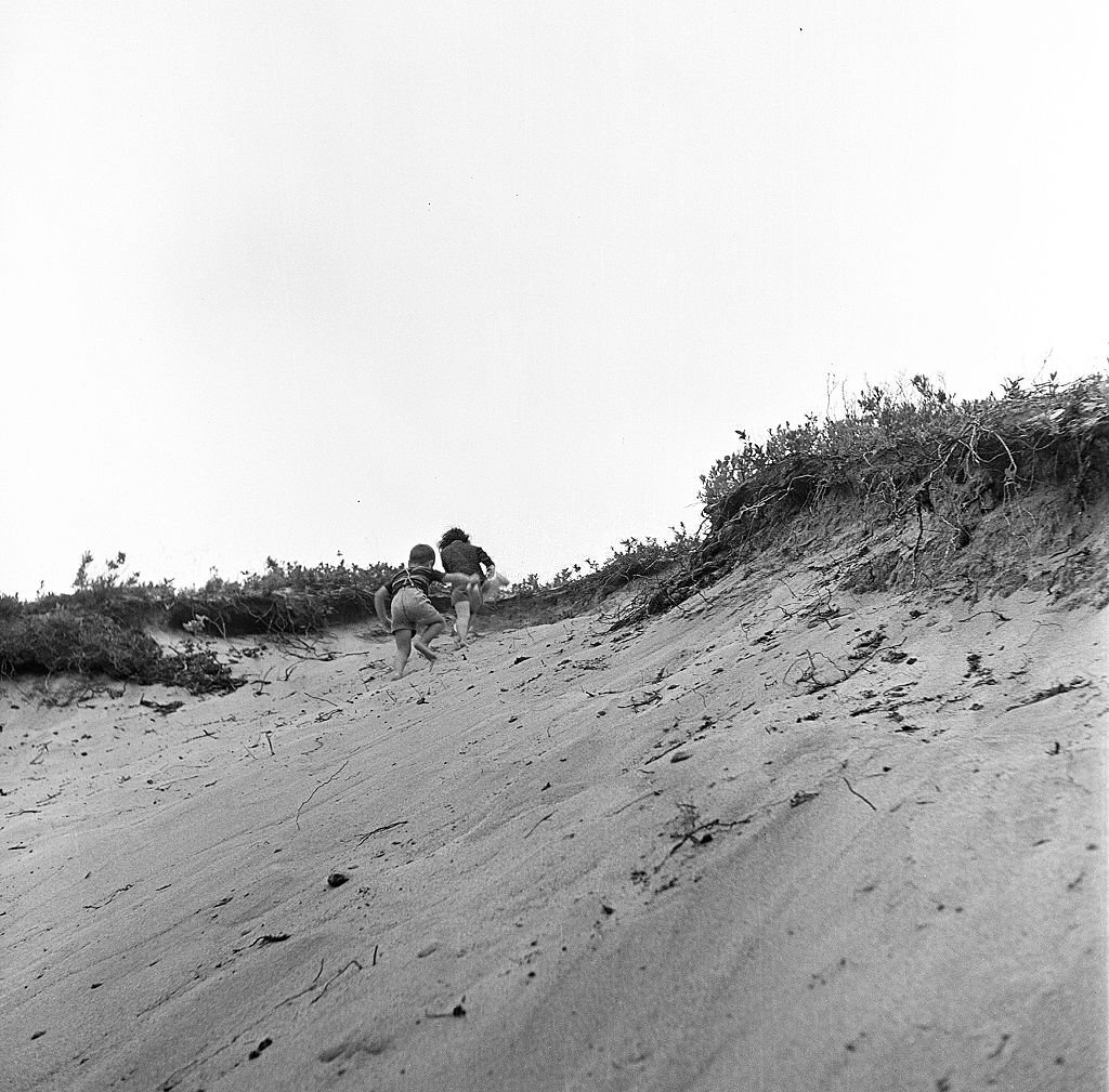 Two young children, a boy and a girl, playin the sand dunes of the beach, Provincetown, Massachusetts, 1948.