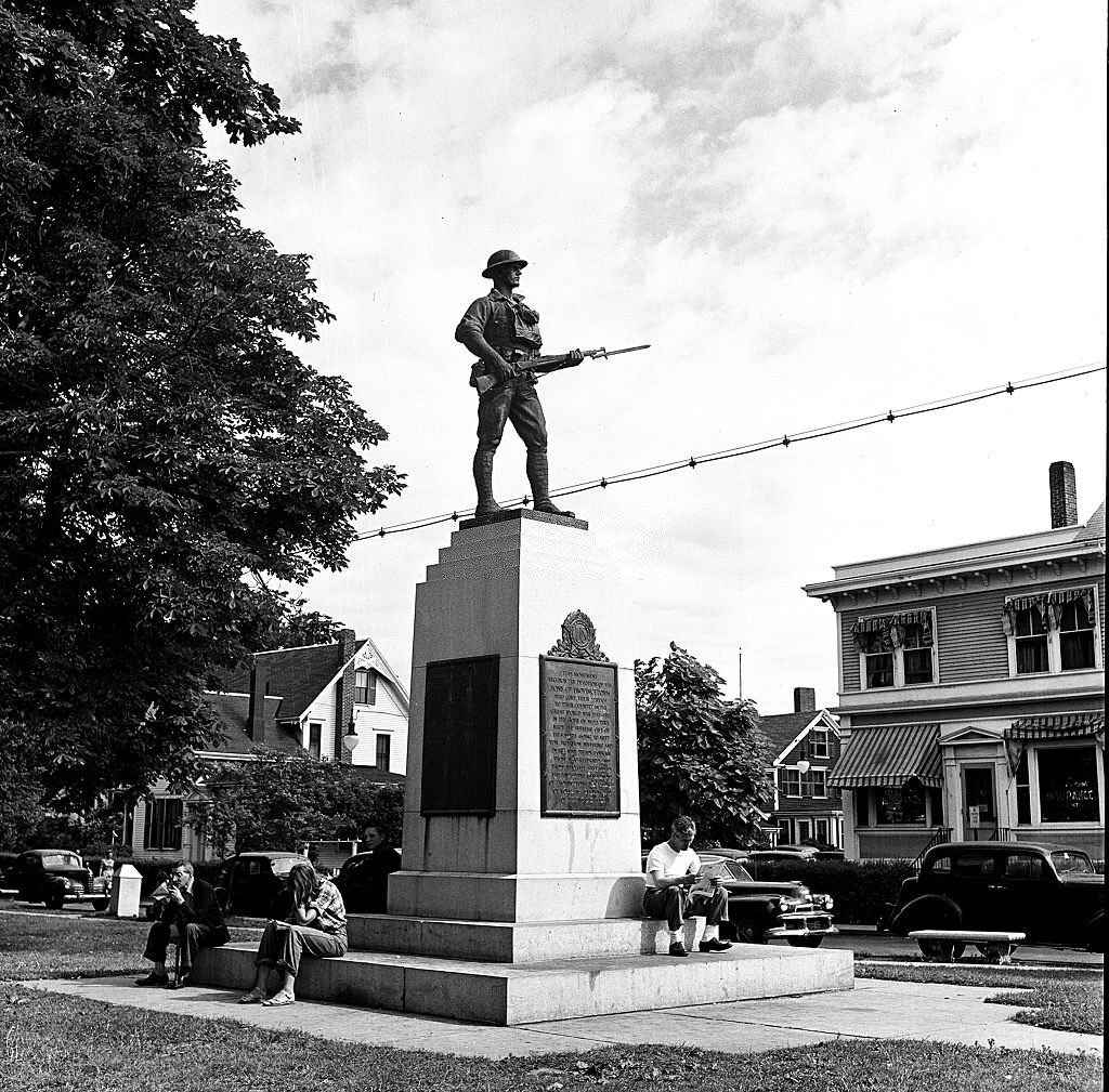 View of people relaxing at the foot of the monument to soldiers who served during the First World War, Provincetown, Massachusetts, 1948.