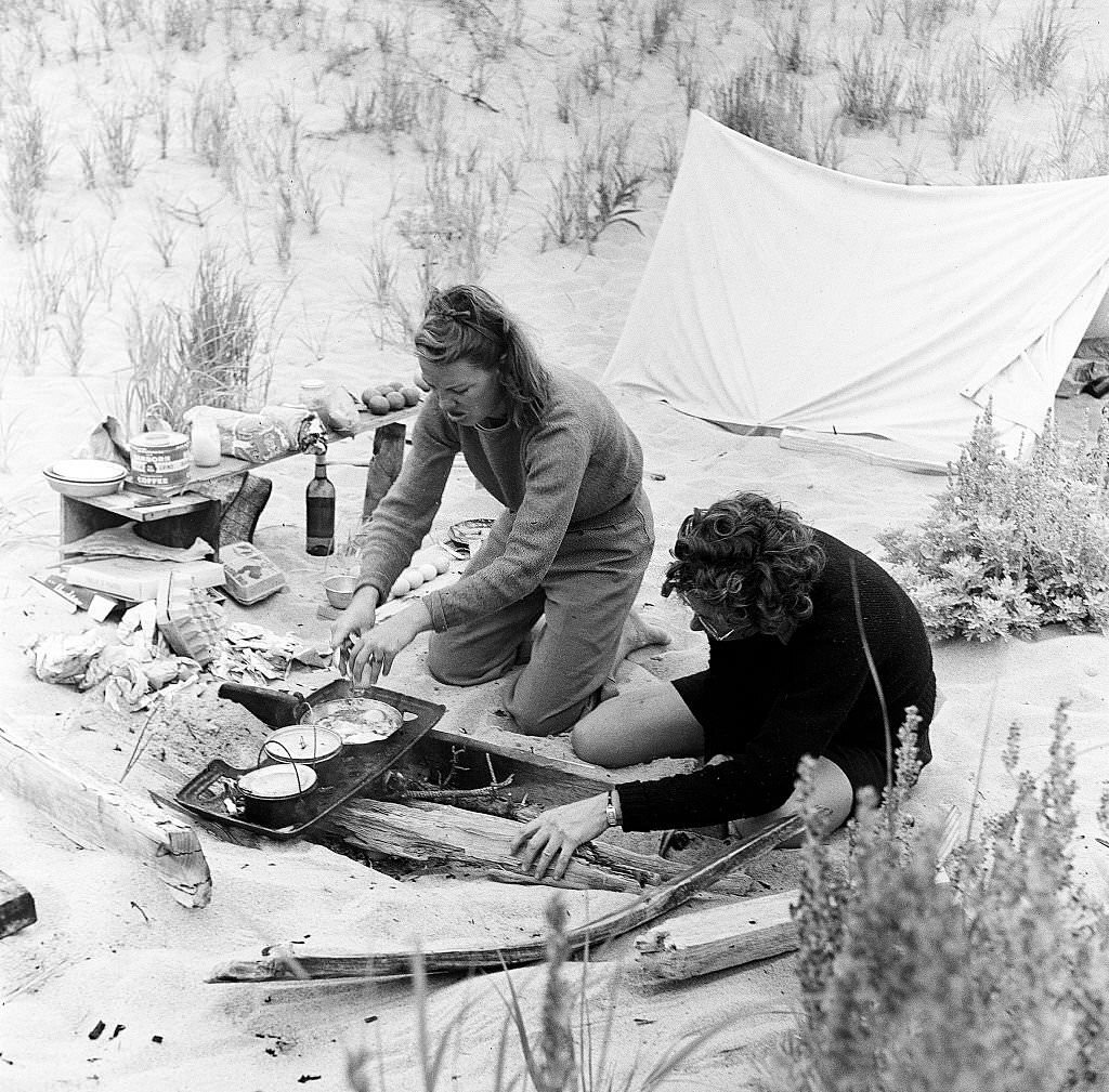 A couple prepares food while camping on the beach on Cape Cod, Provincetown, Massachussetts, 1947.