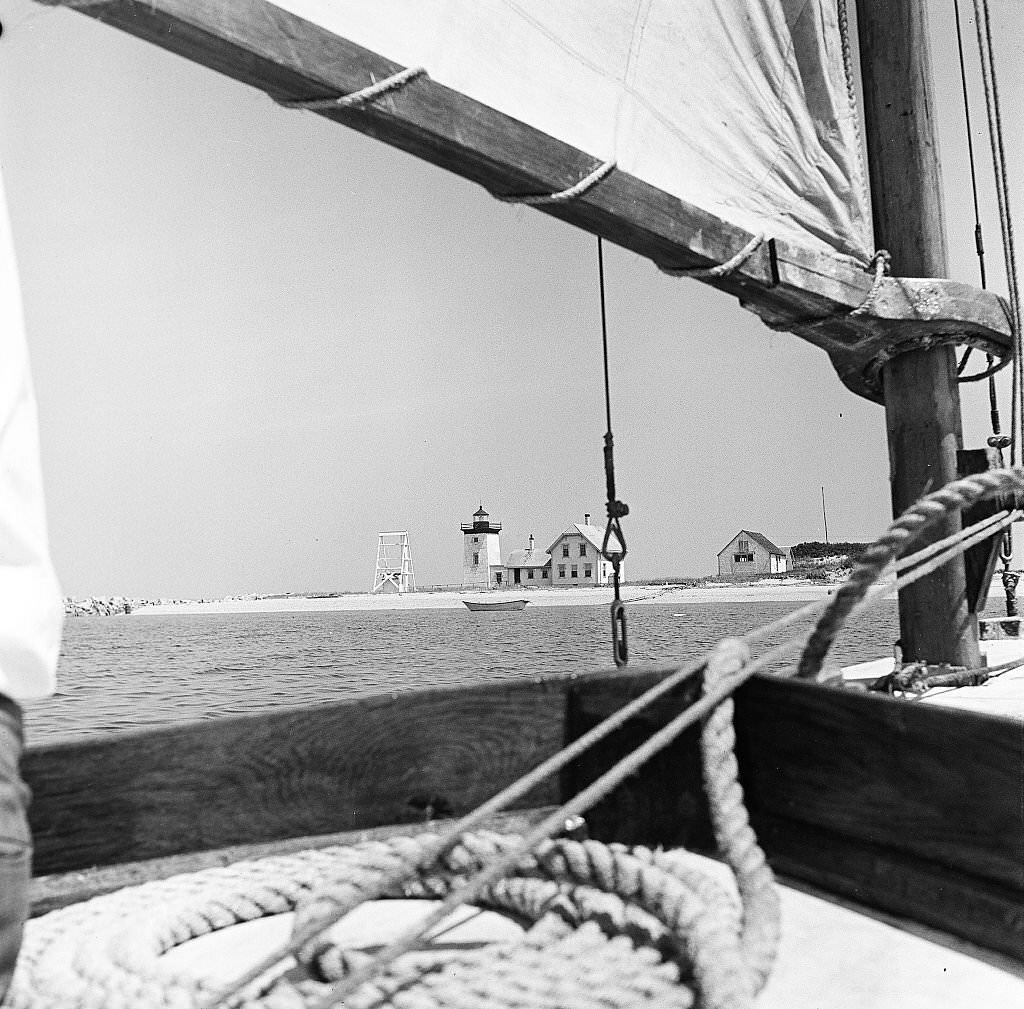 A sailboat approaches a lighthouse on Cape Cod, Provincetown, Massachussetts, 1947.