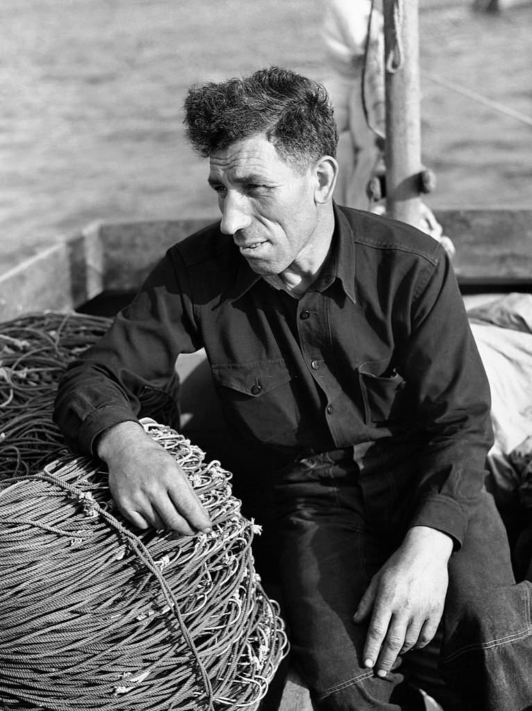 Manuel Zorra, known as the best fisherman on the cape, runs a small boat with a minimum crew because of the bad fishing conditions. Provincetown, Massachusetts, August 1940.