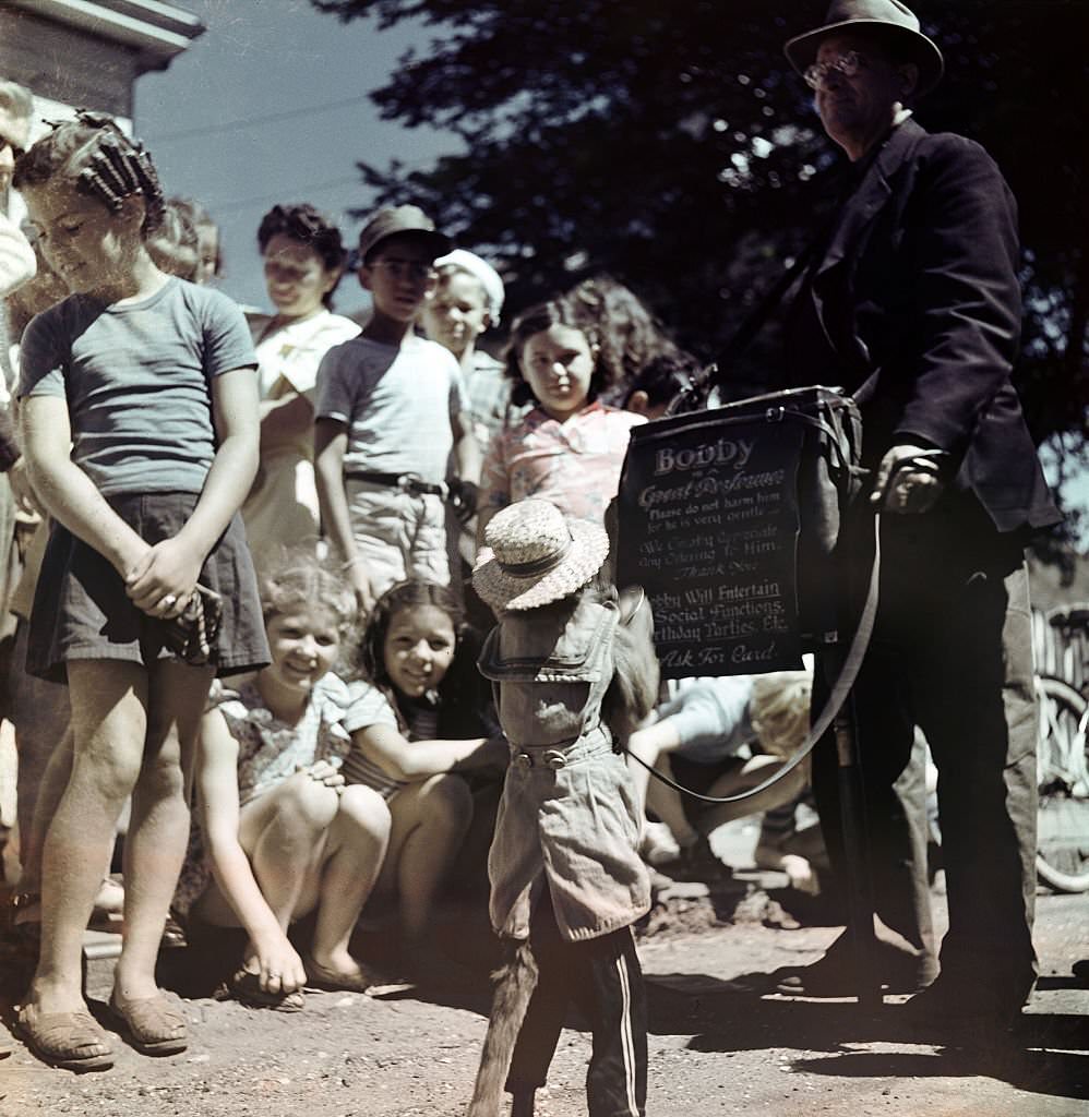 Bobby, a trained monkey, entertains a group of children gathered around, Provincetown, Massachusetts, 1948.