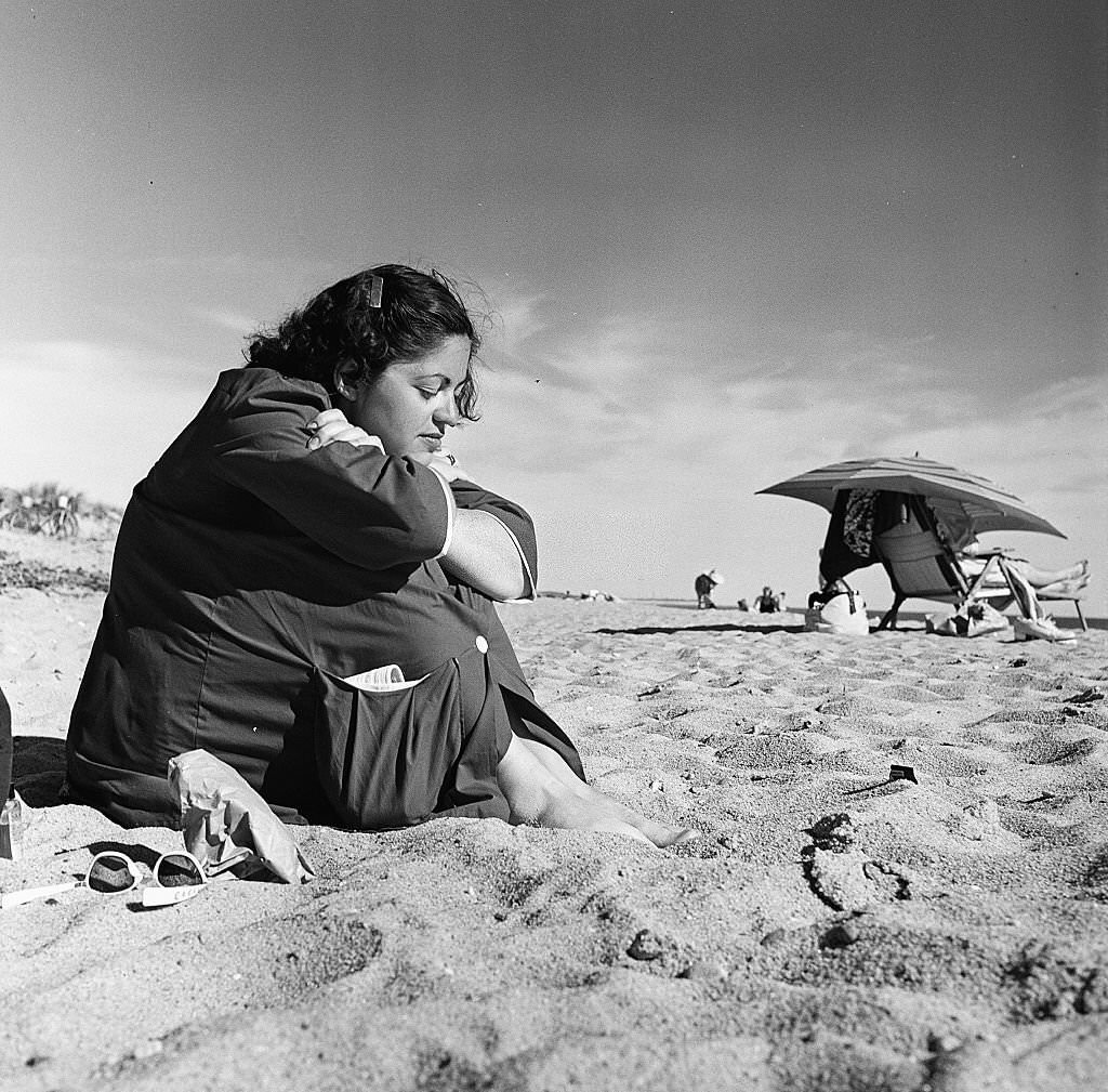 A young woman sits pensively on the beach on Cape Cod, Provincetown, Massachussetts, 1947.