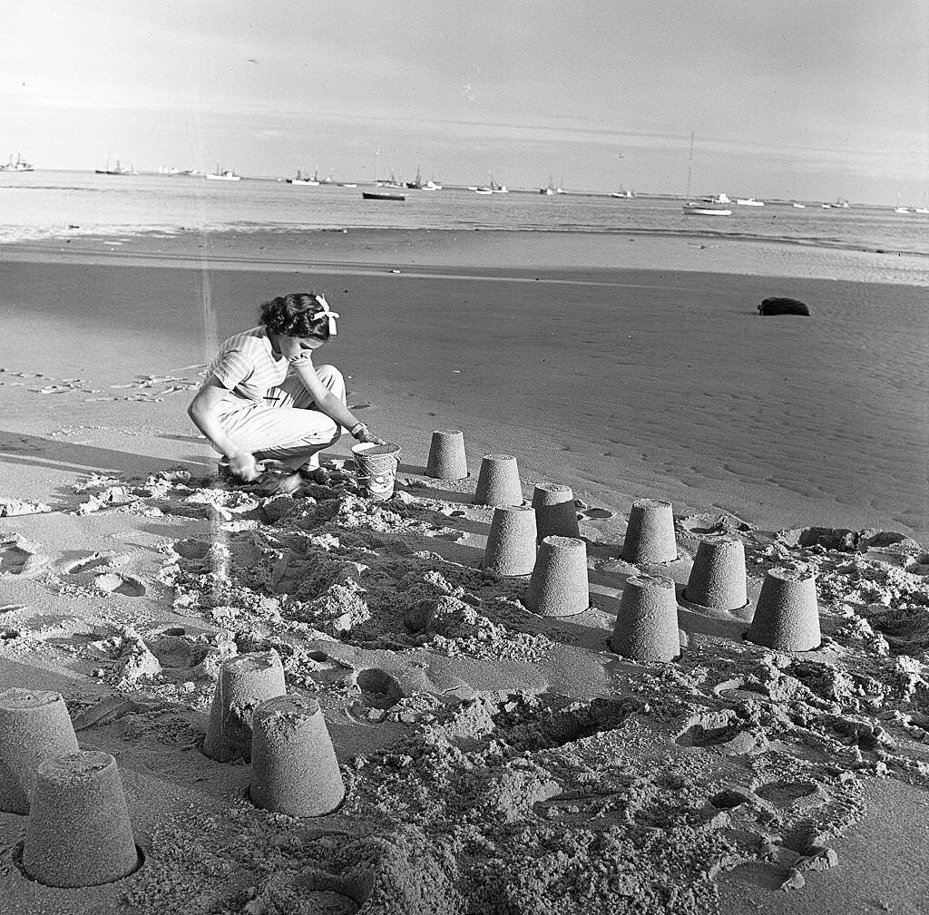 A young girl builds sand castles on the beach, Provincetown, Massachusetts, 1948.