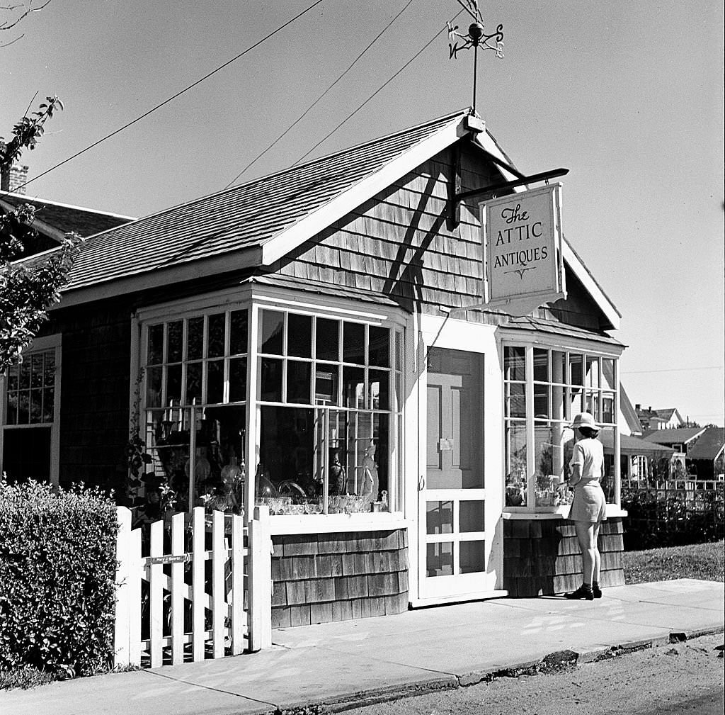 View of a woman looking into the window of the Attic Antiques shop, Provincetown, Massachusetts, 1948.