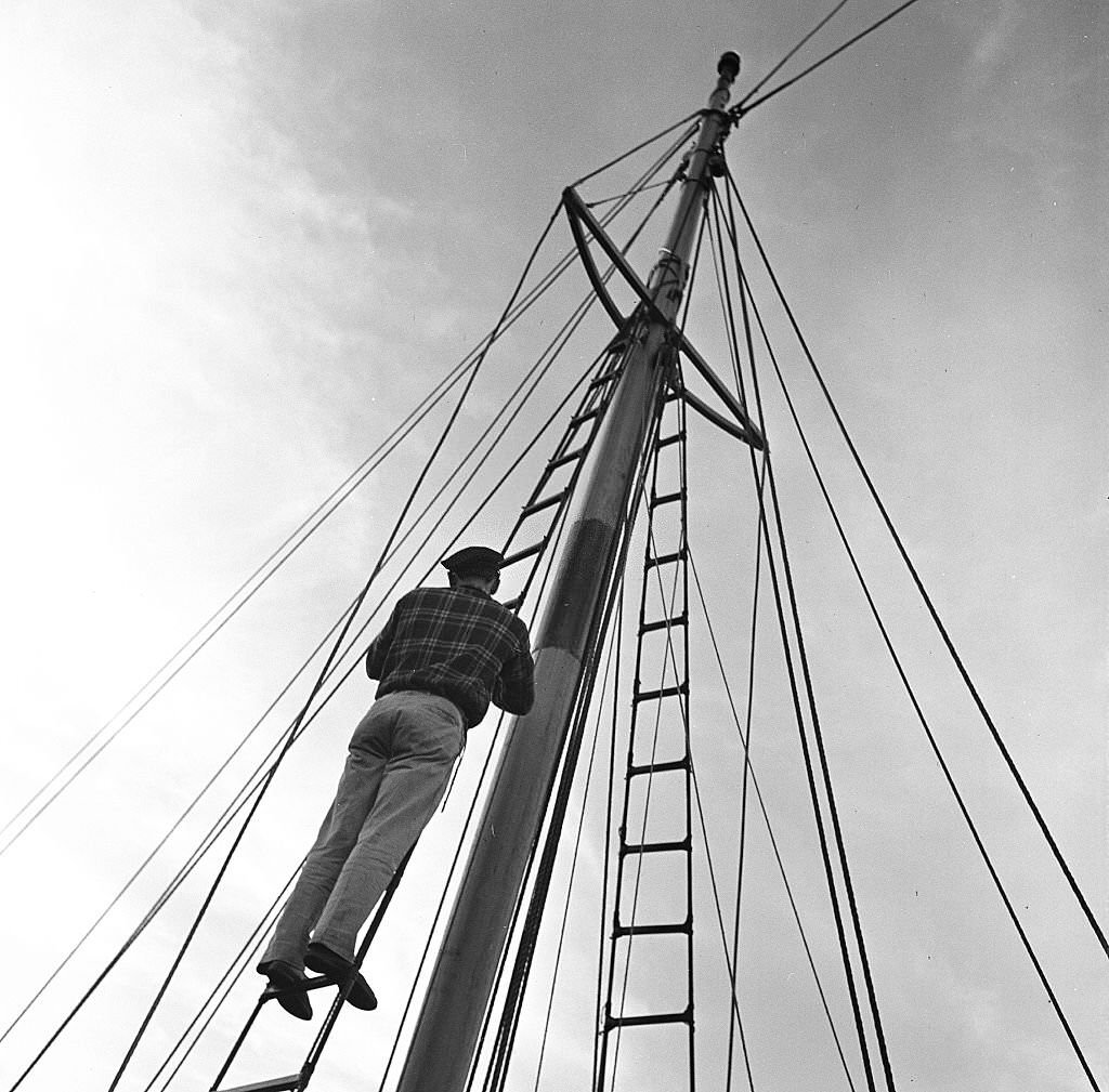 A man climbs up the mast of a sailboat, Provincetown, Massachusetts, 1948.