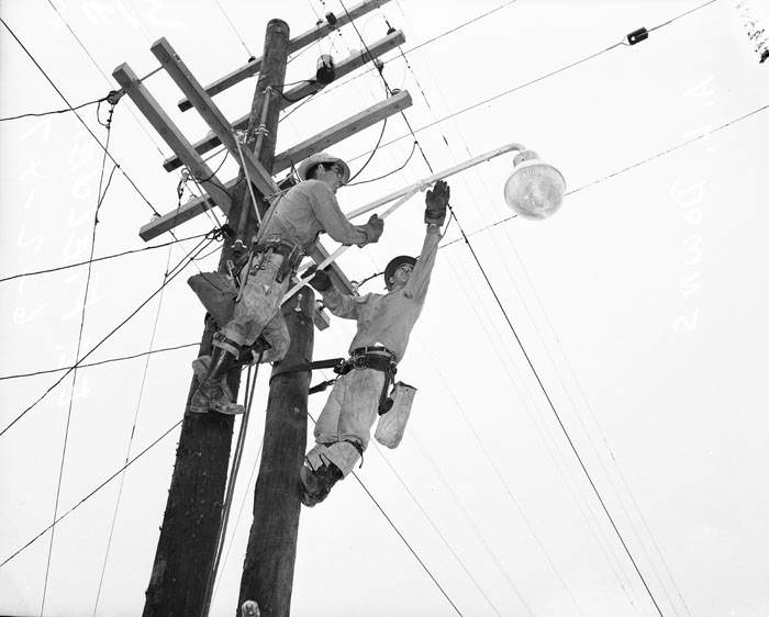 E.F. Fielder and A.L. Downs installing light on utility pole, 1947