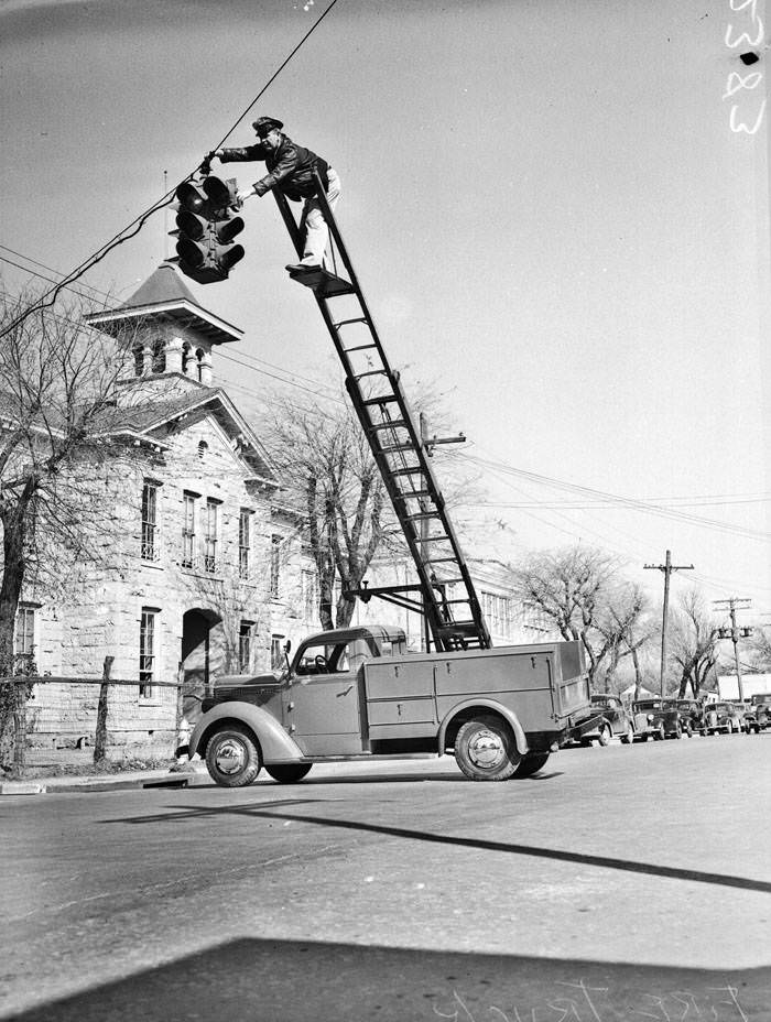 Lineman P. Stowe repairing a traffic light, 1940