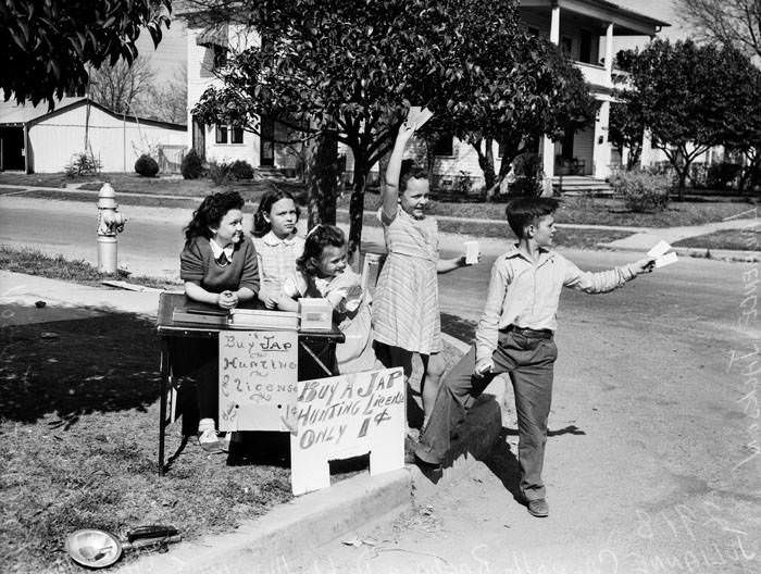 Children selling ''permits'' at sidewalk stand, 1942