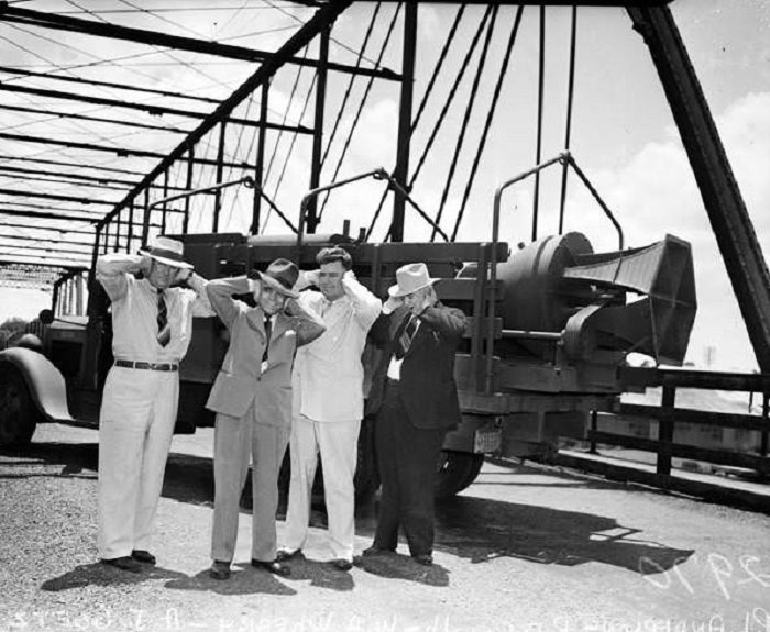 Men on Hays Street bridge holding hands over ears, 1942