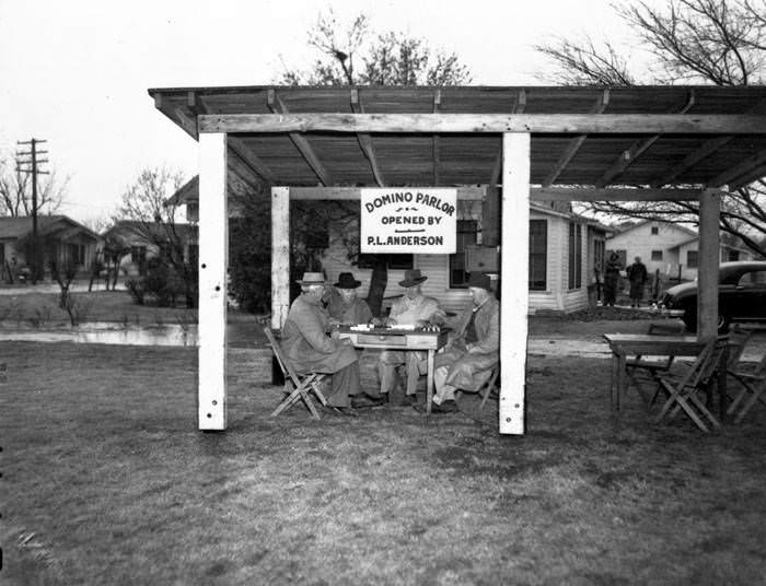 Men playing dominoes under an open air shed, 1947