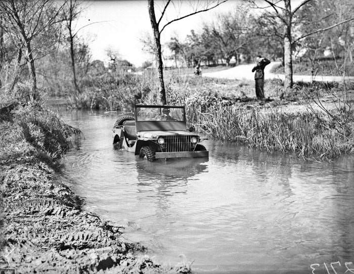 Military police demonstrate ''blitz buggy'' jeep in Salado Creek, 1941