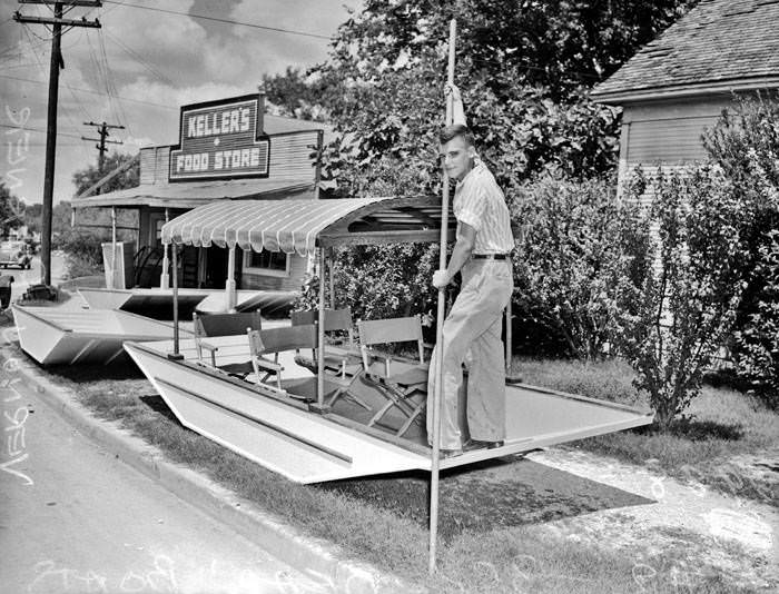 Vernon Poerner, posed with flat-bottom boat he helped build, 1942