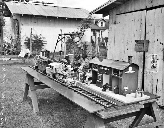 Jack W. Davis and model wooden train and station, 1947