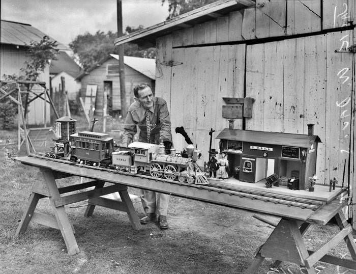 Jack W. Davis and model wooden train and station, 1947