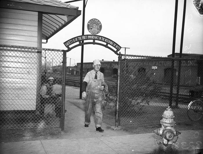 Train Engineer J.O.Sowell walks through SP Gate, 1946
