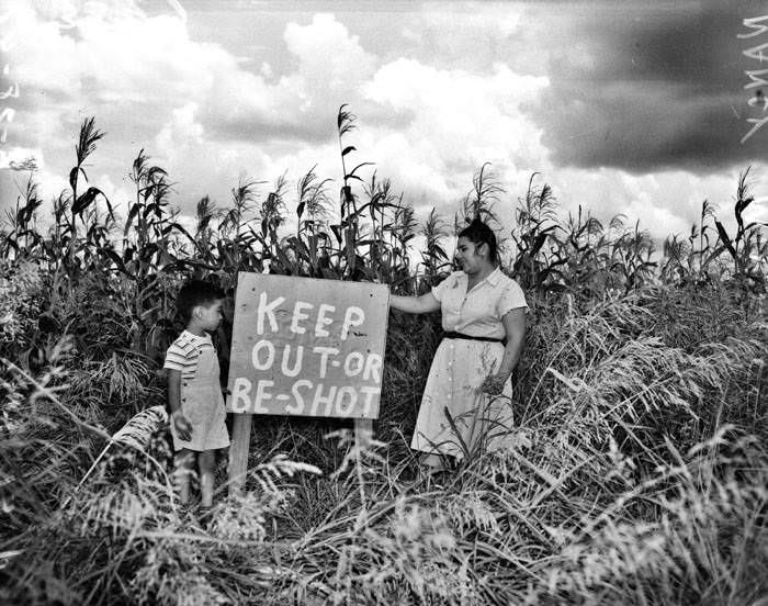 Nancy Mireles and son Joel, with sign in corn field, 1948