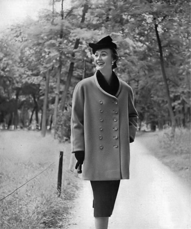 Sophie Malgat in short overcoat of beige Forstmann wool and black velvet collar copied by Seymour Fox from design by Cristobal Balenciaga, Vogue, October 1, 1950