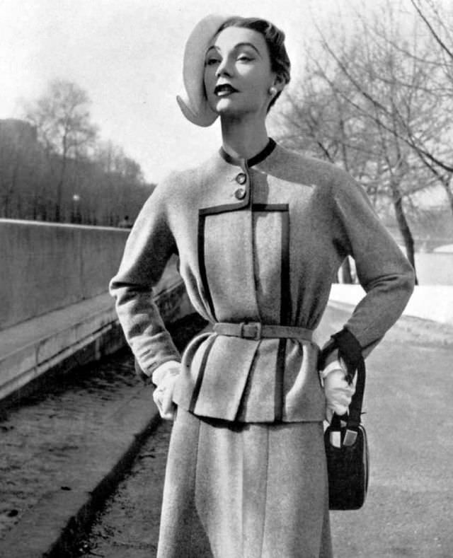Sophie Malgat in elegant mottled tweed jacket, black braid highlights the neck and front panel, narrow fabric belt marks the waist, skirt is cut on the bias, by Jeanne Paquin, 1952