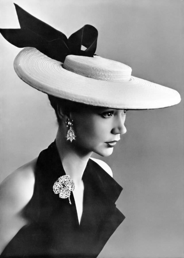 Sophie Malgat in large straw boater adorned with black satin bow by Legroux Soeurs, brooch and earrings by Roger Scémama, 1952