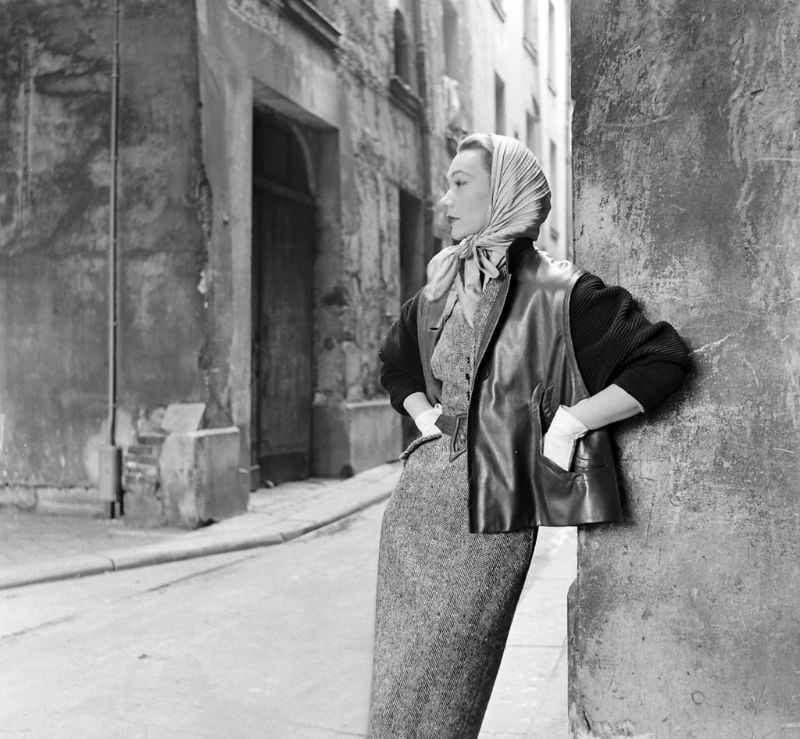 Sophie Malgat is wearing slim tweed dress under leather jacket with knit sleeves by Givenchy, Paris, February 1952