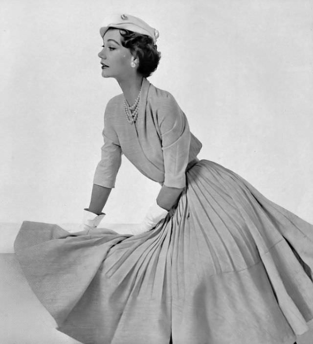 Sophie Malgat in greige wool afternoon dress, skirt is full with half-way pleats, by Maggy Rouff, hat by Svend, 1953